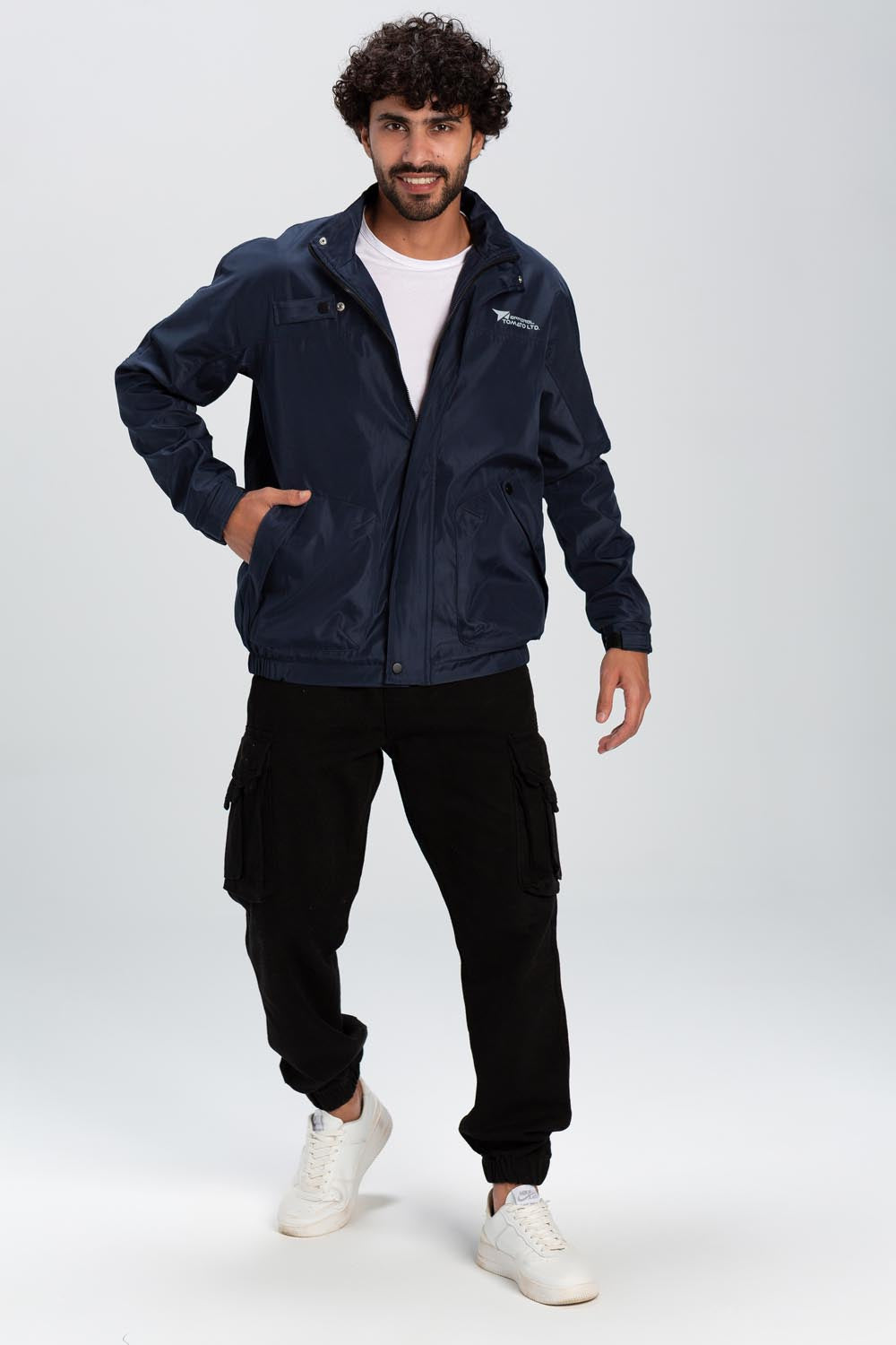 A man wears a navy blue waterproof jacket with a full zipper, front pockets, and a small chest logo.