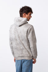 Men's tie-dye long sleeve slim fit hood sweatshirt in grey and white with blue jeans.