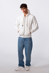 Men's washed effect slim fit full zip hood sweatshirt in white paired with blue jeans.