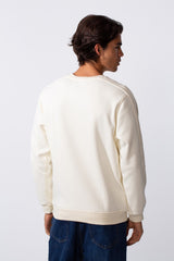 Rear view of a man wearing a cream-colored slim fit round neck sweatshirt and blue jeans.