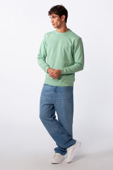 Men's plain mint green round neck slim fit sweatshirt paired with blue jeans and white sneakers.