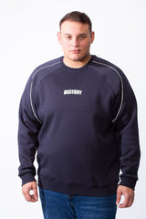 A man wears a navy blue big size crew neck sweatshirt with white piping and a DESTROY graphic.