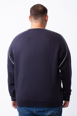 Rear view of a man wearing a navy blue big size crew neck sweatshirt with white piping on the shoulders.