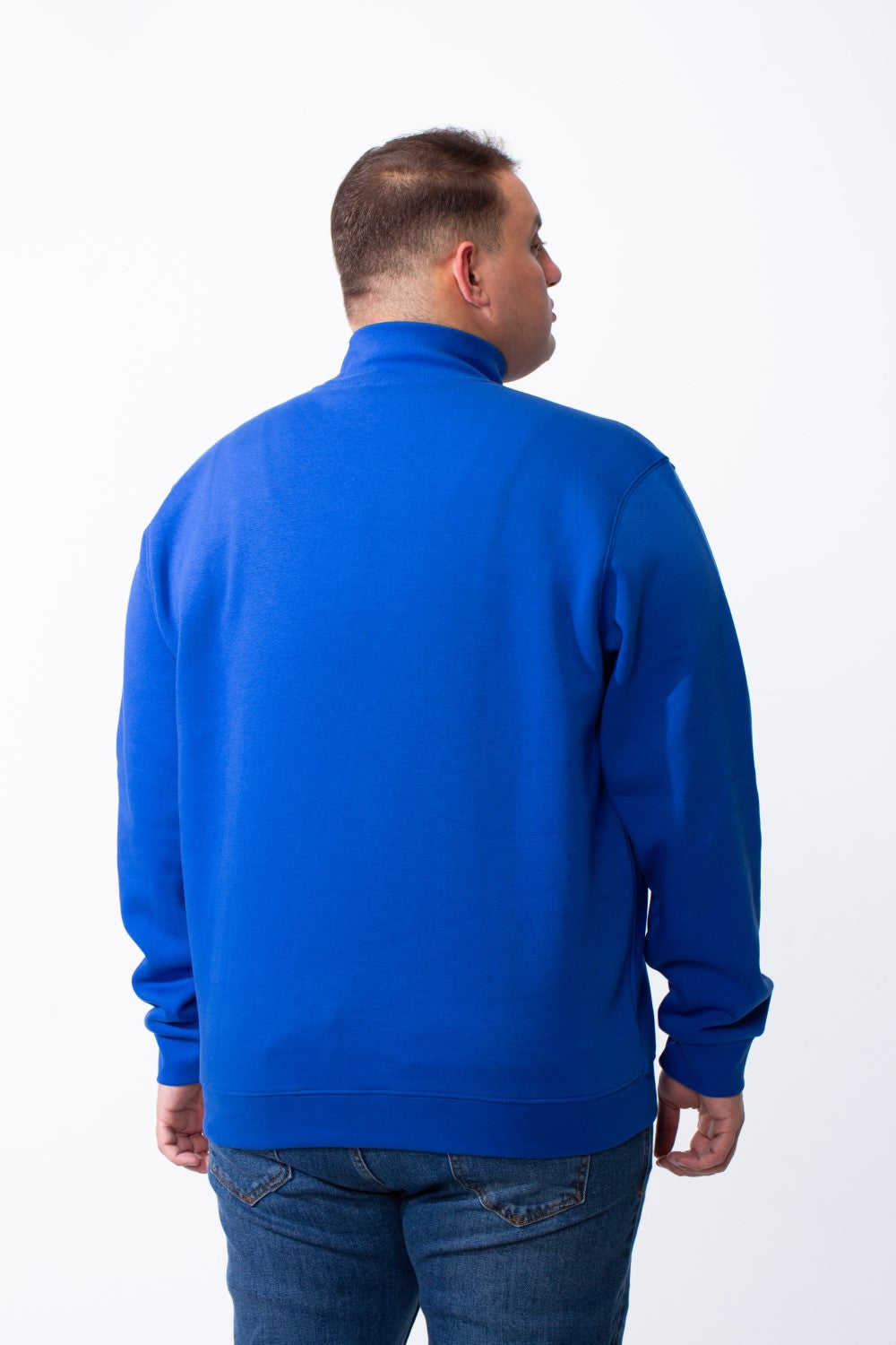 Rear view of a man wearing a royal blue big size mock neck sweatshirt with ribbed cuffs.