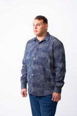 A man wears a big size blue geometric patchwork button-down shirt with a chest pocket.