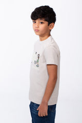A boy wears a light grey ribbed crew neck t-shirt with a playful graphic on the front.