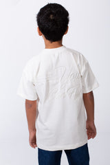 Back view of a boy wearing a white oversized crew neck t-shirt with typography embroidery.