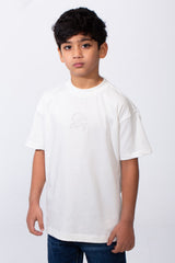 A boy wears a white oversized crew neck t-shirt with subtle typography embroidery on the chest.