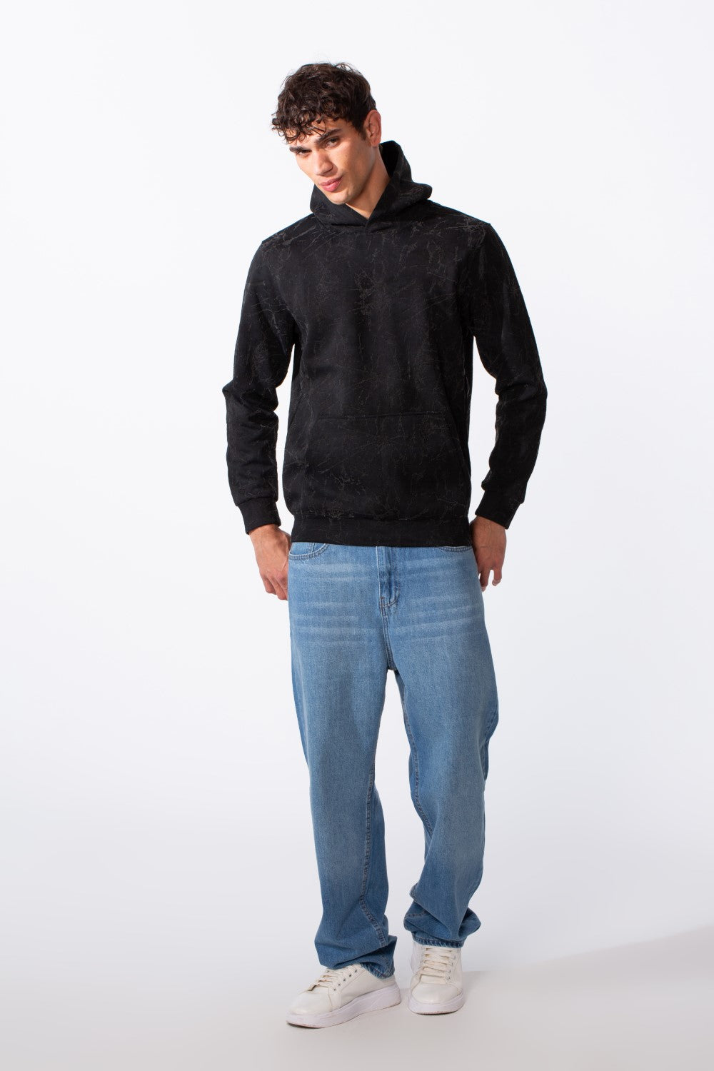Men's tie-dye long sleeve slim fit hood sweatshirt in black with blue jeans and white sneakers.
