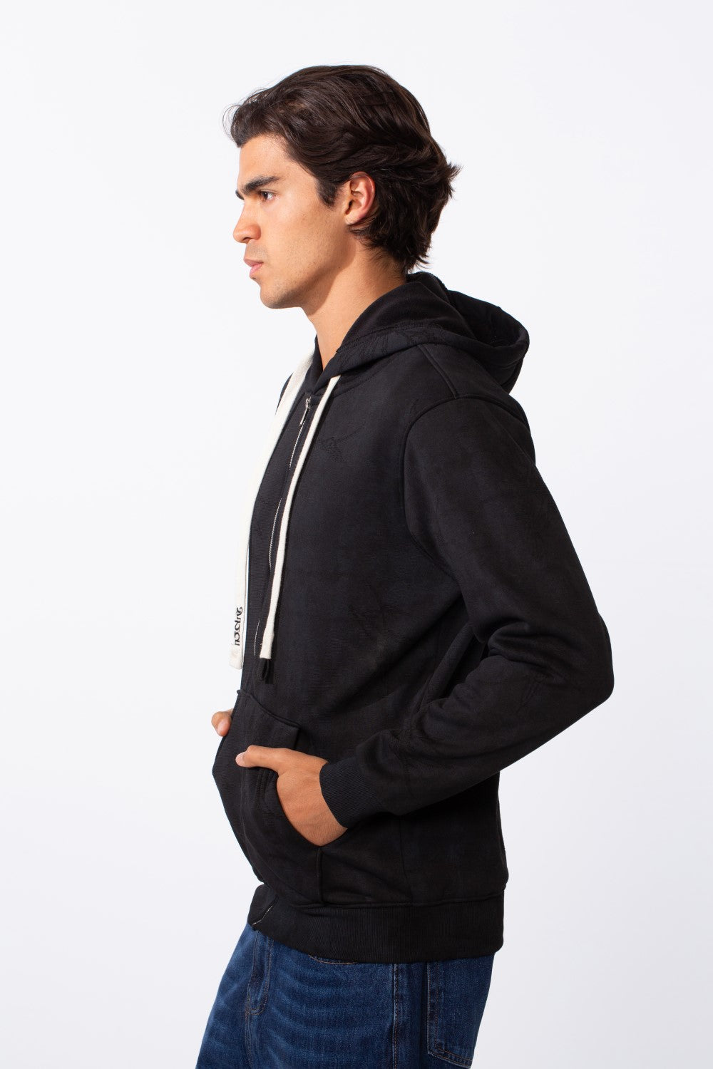 Side view of a man wearing a black washed effect slim fit full zip hoodie with white drawstrings.