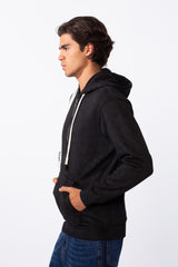 Side view of a man wearing a black washed effect slim fit full zip hoodie with white drawstrings.