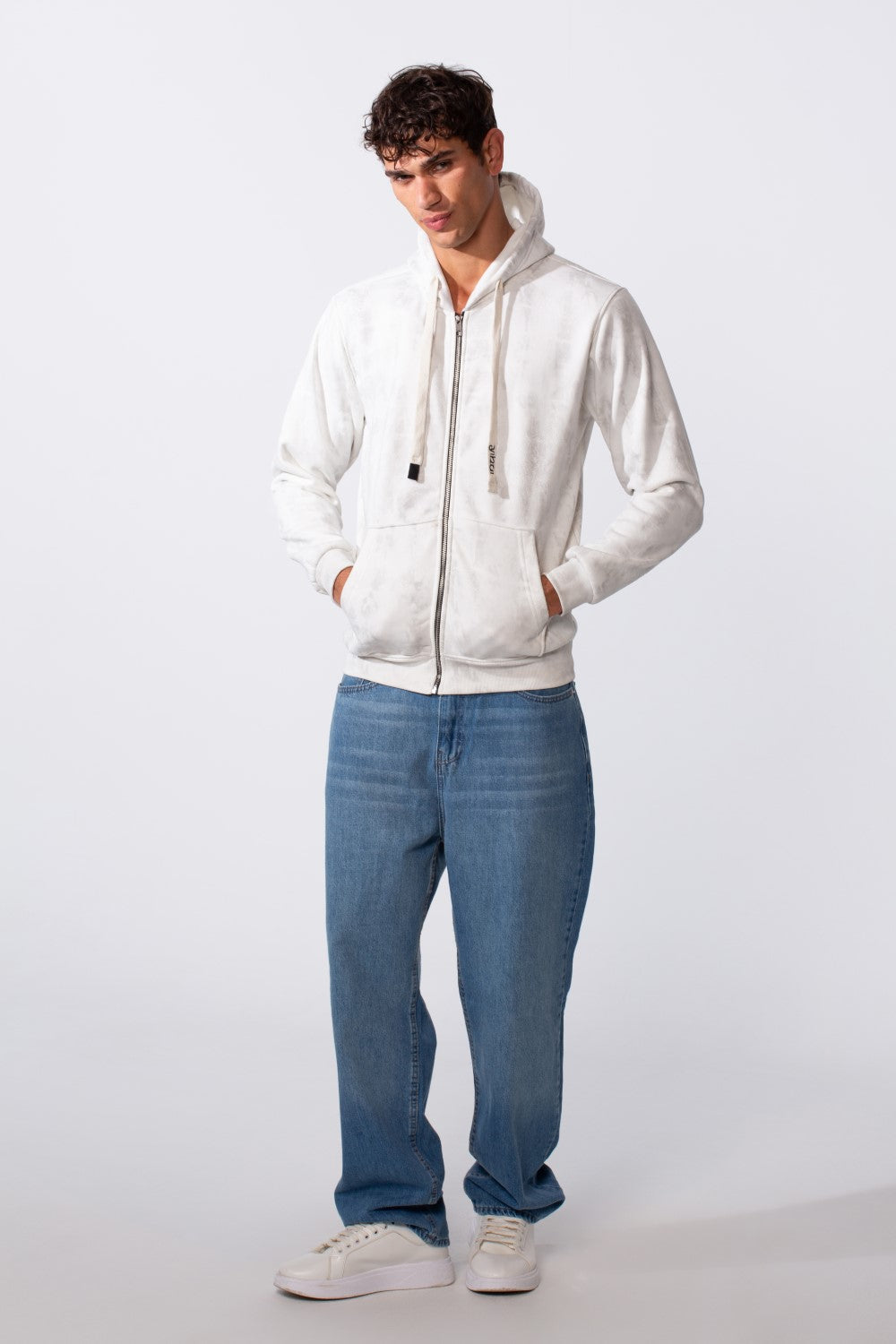 Men's washed effect slim fit full zip hood sweatshirt in white paired with blue jeans.