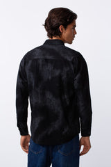 Rear view of a man wearing a black washed gabardine regular fit shirt with blue jeans.