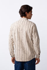 Rear view of a man wearing a slim fit cream velvet shirt with thin vertical black stripes.