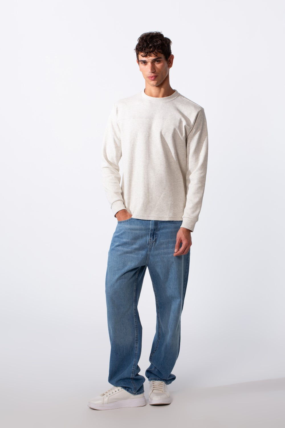 Men's plain essential round neck slim fit sweatshirt in light grey paired with blue jeans.